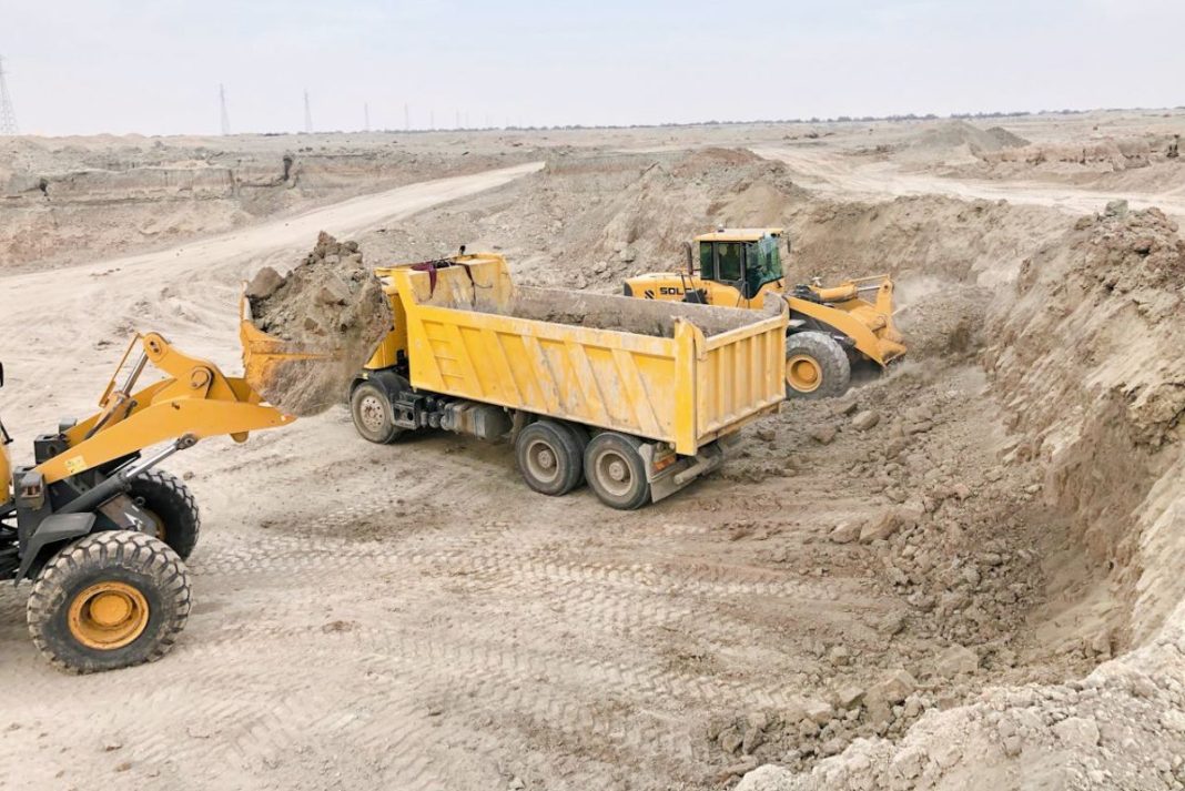 koparka i przyczepa z piachem